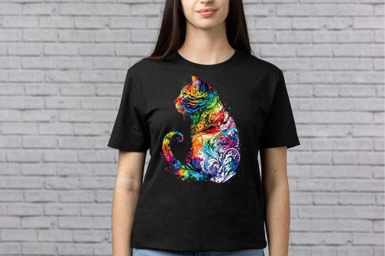 May include: A black t-shirt with a colorful, abstract design of a cat. The cat is sitting with its tail curled around its body. The design is made up of swirls and dots in shades of blue, green, yellow, orange, red, and purple.