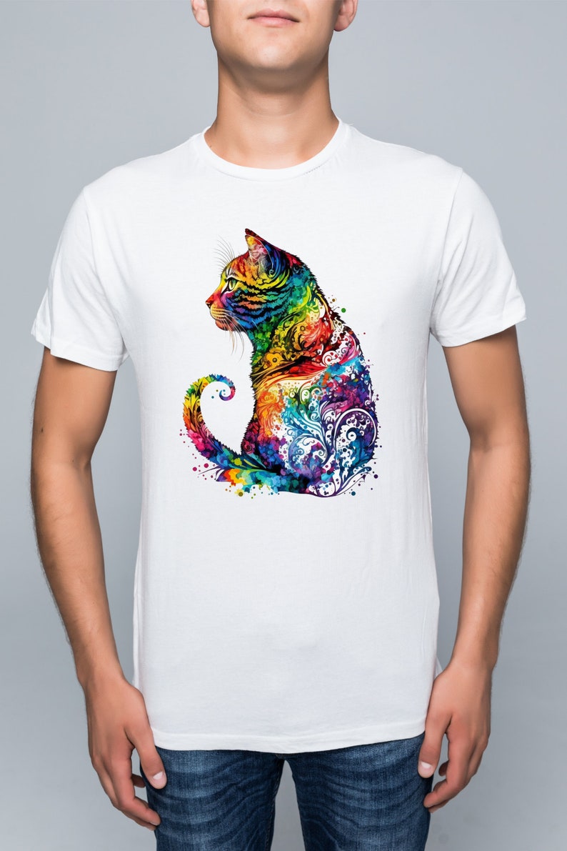 May include: A white t-shirt with a colorful graphic of a cat sitting with its tail curled around its body. The cat is made up of a variety of colors, including blue, green, yellow, orange, and red. The graphic is surrounded by a watercolor effect.