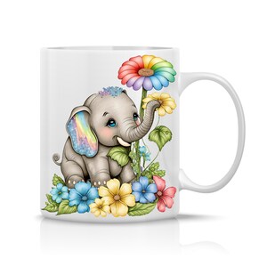 May include: A white ceramic mug with a colorful illustration of a cartoon elephant with a rainbow ear, surrounded by flowers. The elephant is smiling and looking to the right. The flowers are in shades of pink, yellow, blue, and green.