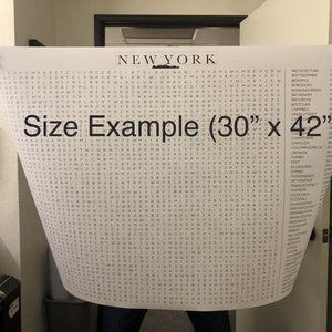 May include: A black and white word search puzzle featuring the word "NEW YORK" at the top. The puzzle is printed on a white sheet of paper and is being held by a person's hands. The text "Size Example (30" x 42")" is printed in black at the bottom of the puzzle.