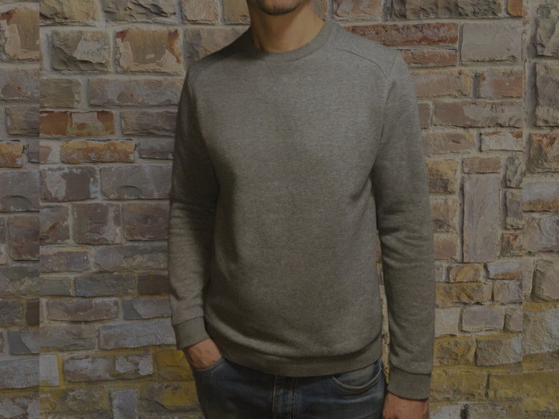May include: A gray long-sleeved sweatshirt with a crew neck.