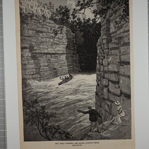 May include: A black and white engraving depicting a narrow, rocky gorge with a rushing river. A small boat with people in it is navigating the rapids. Two people are standing on the edge of the gorge, watching the boat.