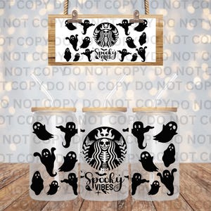May include: Three clear glass tumblers with wooden lids and straws, decorated with black ghost silhouettes and a Starbucks-inspired logo featuring a skeleton. The words "Spooky Vibes" are also displayed. A wooden sign with ghost graphics hangs above.