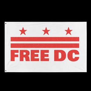 May include: A rectangular white flag featuring a red graphic design consisting of three five-pointed stars positioned above two horizontal stripes. Below the stripes, the text "FREE DC" is printed in large, bold, red capital letters.