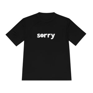 May include: Black t-shirt with the word "sorry" printed in white on the front. The "o" in sorry is replaced with a cookie.