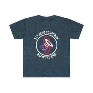 May include: Dark blue t-shirt with a white circular graphic. The graphic features a hat with red and white stripes and blue stars, encircled by a red ring. The text "94th Aero Squadron" and "Hat in the Ring" are also in the graphic.