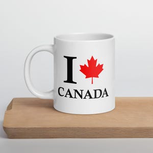 May include: White ceramic coffee mug with a black "I love Canada" design and a red maple leaf.