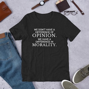 May include: Dark gray t-shirt with white text that reads "We don't have a difference of opinion. We have a difference in morality."