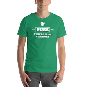 May include: A green t-shirt with the text "PUBS" above "THEY'RE IRISH SUNBLOCK" in white. A white shamrock is above the word "PUBS". The shirt is short-sleeved.
