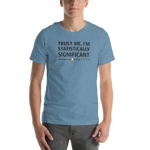 May include: A light blue t-shirt with the text "TRUST ME, I'M STATISTICALLY SIGNIFICANT" in black. Below the text is a horizontal line with a yellow dot and the text "p<0.05". The shirt is made of a soft material.