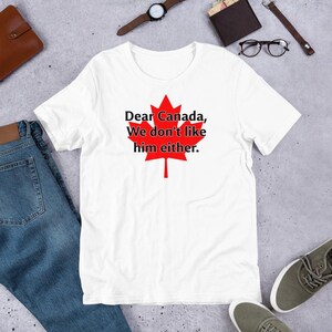 May include: White t-shirt with a red maple leaf and the text "Dear Canada, We don't like him either."