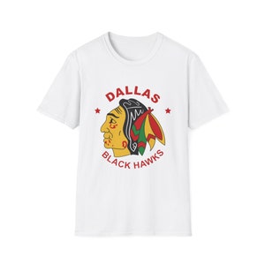 May include: White t-shirt with a red, black, green, and yellow logo that says "Dallas Black Hawks" with a Native American headdress design.