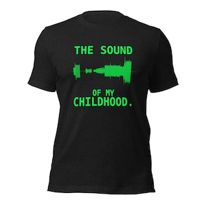Könnte beinhalten: Ein schwarzes Kurzarm-T-Shirt mit einer leuchtend grünen Grafik einer Schallwelle auf der Brust. Über und unter der Schallwelle steht der Text THE SOUND OF MY CHILDHOOD in einer fetten, serifenlosen, leuchtend grünen Großbuchstabenschrift.