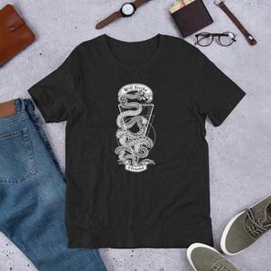 May include: A dark heather grey t-shirt with a white graphic of a snake coiled around a triangle with the text "Will Strike If Provoked".