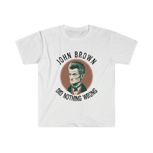 May include: White t-shirt with a vintage-style illustration of John Brown, a historical figure, in a circle with the text "John Brown Did Nothing Wrong".