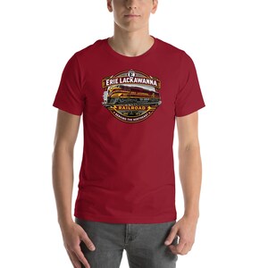 May include: Maroon short-sleeve t-shirt featuring a detailed Erie Lackawanna Railroad logo. The logo includes a train illustration, the text "ERIE LACKAWANNA RAILROAD", and the years 1950 and 1976. The shirt is worn by a person.