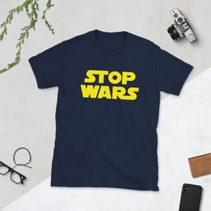 May include: A navy blue t-shirt with the text "STOP WARS" in yellow.