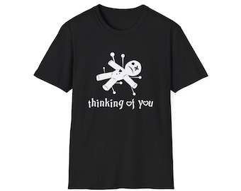 May include: Black t-shirt with a white graphic of a voodoo doll with pins and the text "thinking of you".
