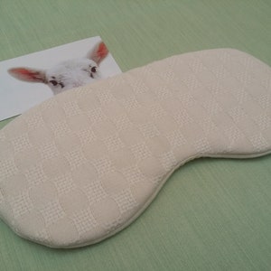 Sleeping eye mask . soft Ivory cream  coloured silk & wool fabric with gentle hatch pattern  on outer side and plain cream wool challis material on side next to eyes. White elastic strap hand made by Uan Wool, Angus, Scotland