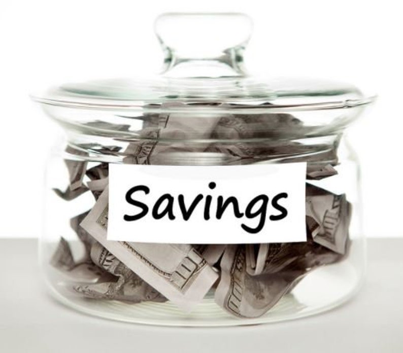May include: A glass jar with a lid filled with crumpled dollar bills. A white label on the front of the jar reads "Savings".