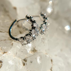 May include: Silver hoop earrings with a row of clear cubic zirconia stones.
