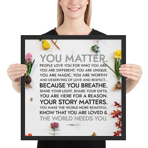 May include: A framed inspirational quote with a white background and black text. The quote reads "You Matter. People love you for who you are. You are different. You are unique. You are magic. You are worthy and deserving of love and respect... Because you breathe. Shine your light. Share your gifts. You are here for a reason. Your story matters. You make the world more beautiful. Know that you are loved & the world needs you." The quote is surrounded by a variety of flowers and plants.