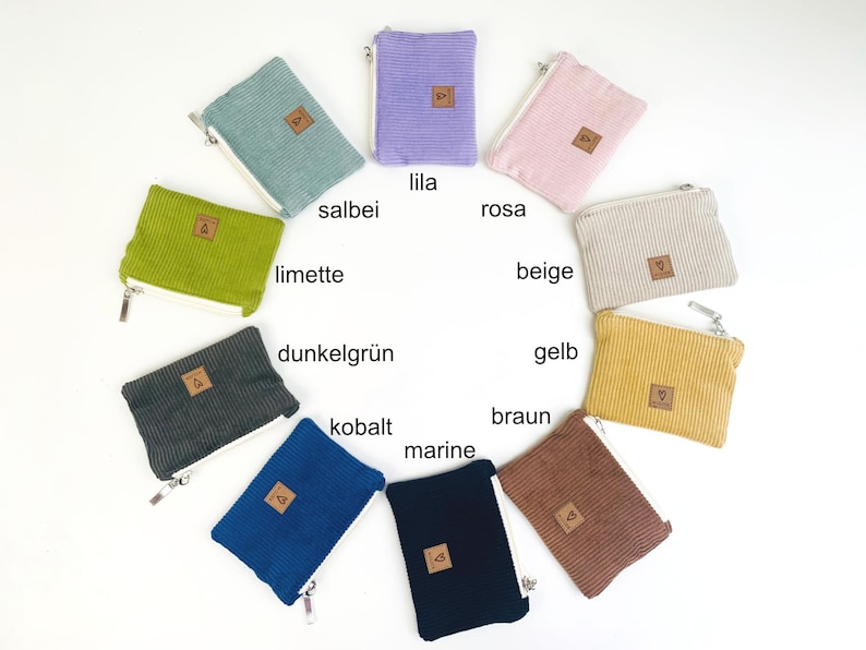 May include: Assortment of 10 small zippered pouches in various colors, including lime green, dark green, navy blue, brown, beige, yellow, pink, purple, and gray. Each pouch has a small brown leather tag with a heart symbol.