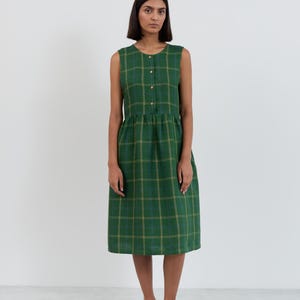 Full-length front view of the FERN sleeveless linen midi dress in Green Check showing round neckline, button-front bodice, gathered waist, and plaid pattern