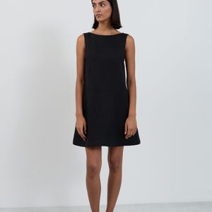Full-length front view of the CECILIA Black linen mini dress showing the clean boat neckline and A-line shape falling above the knee