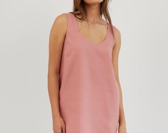 May include: A sleeveless, pink linen dress with a scoop neck. The dress is a simple, casual style.