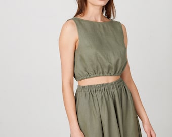May include: A sage green linen crop top and matching skirt set. The top has a scoop neck and a fitted bodice with an elastic waistband. The skirt is a-line and has an elastic waistband.