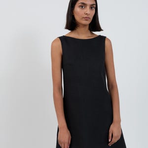Front close-up of the CECILIA Black linen mini dress showing the straight boat neckline and slight A-line flare through the body