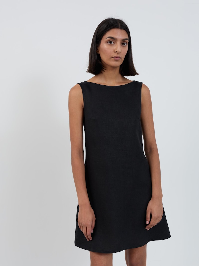 Front close-up of the CECILIA Black linen mini dress showing the straight boat neckline and slight A-line flare through the body