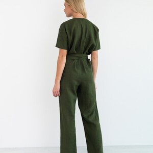 May include: A green linen jumpsuit with a self-tie belt and short sleeves.
