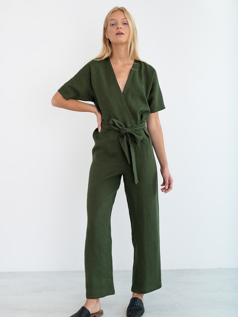 May include: A green linen jumpsuit with a wrap-style bodice and a self-tie belt. The jumpsuit has short sleeves and a V-neckline.