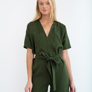 May include: A green linen jumpsuit with a wrap-style bodice and a self-tie belt. The jumpsuit has short sleeves and a V-neckline.