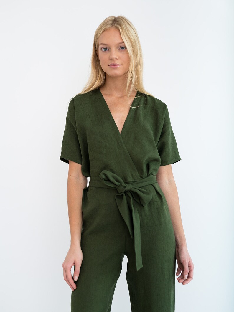 May include: A green linen jumpsuit with a wrap-style bodice and a self-tie belt. The jumpsuit has short sleeves and a V-neckline.