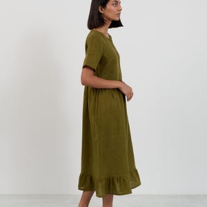 Side and back view of the SAGE Moss Green linen midi dress showing the full silhouette from neckline through gathered skirt to ruffle hemline