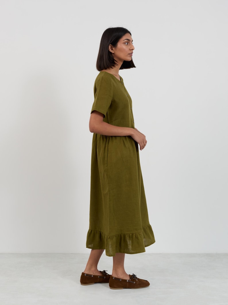 Side and back view of the SAGE Moss Green linen midi dress showing the full silhouette from neckline through gathered skirt to ruffle hemline