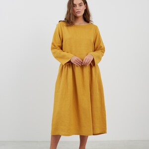 May include: A long-sleeved, mustard yellow linen dress with a loose fit and a boat neckline.