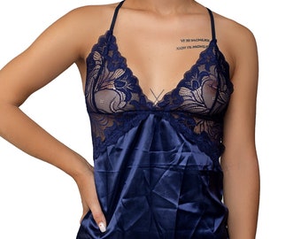 May include: A navy blue satin slip dress with a lace overlay. The lace is a delicate floral pattern and is semi-sheer.
