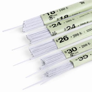 Könnte beinhalten: Eine Sammlung von weißen Blumendrahtbündeln, die mit hellgrünen Papierstreifen umwickelt sind. Auf jedem Streifen sind die Stärken 18, 24, 26, 30 und 35 sowie Mengen von 100 oder 200 Stück aufgedruckt. Die dünnen, geraden Drähte ragen aus den Hülsen.