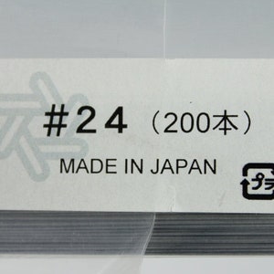 May include: A pack of 200 silver-coloured wire pieces labelled #24, made in Japan. The pack has a recycling symbol.
