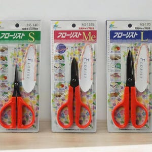 May include: Three pairs of red handled floral shears with black blades. The shears are labeled "Florist" and come in three sizes: S, Me, and L.