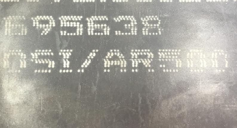 May include: A close-up of a black metal surface with white dot matrix display showing the numbers 695638 and the text "RSI/ARRD".