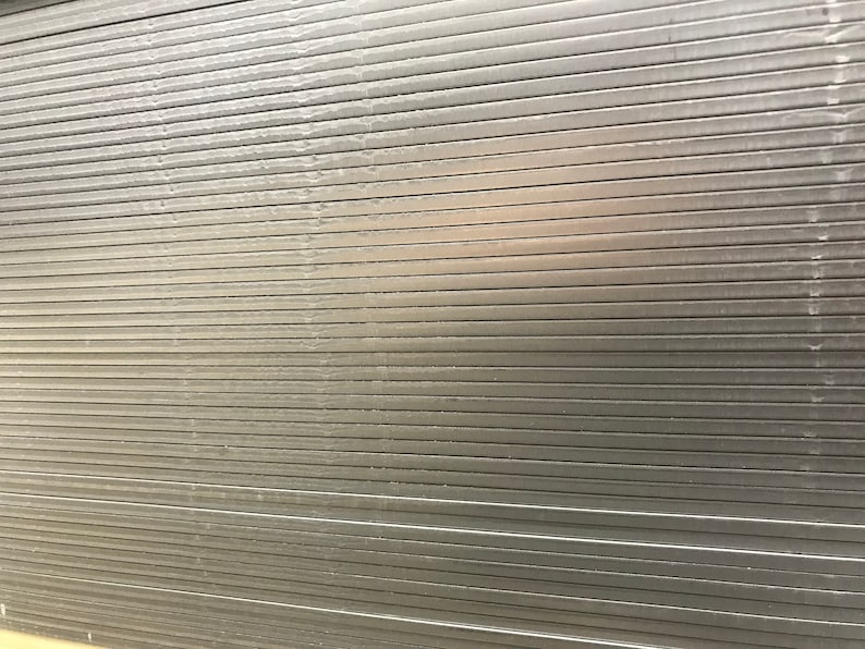 May include: A close-up of a silver metal surface with horizontal lines. The surface is smooth and reflective.