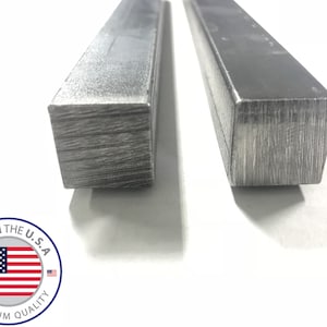 May include: Two pieces of square steel bar stock. The steel is a light gray color and has a rough, unfinished surface. The bars are lying flat on a white surface. The image includes the text "Made in the U.S.A. Premium Quality".