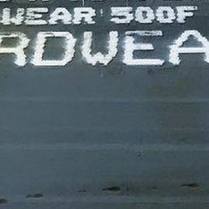 May include: A close-up of a gray metal surface with white lettering that reads "Hardwear 500f Mt Hardwear 5".