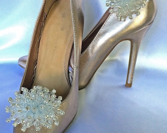 May include: A pair of gold high-heeled shoes with clear crystal embellishments on the toes.