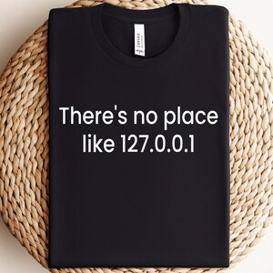 May include: Black t-shirt with white text that reads "There's no place like 127.0.0.1".
